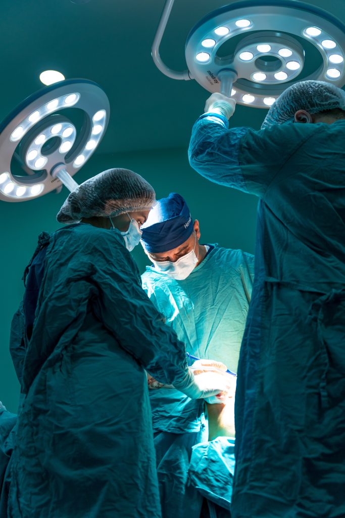A group of doctors dressed in blue perform surgery