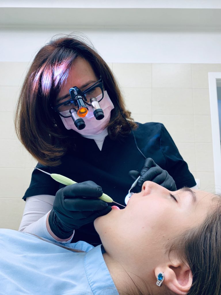 A dentist looks into a females patient's mouth