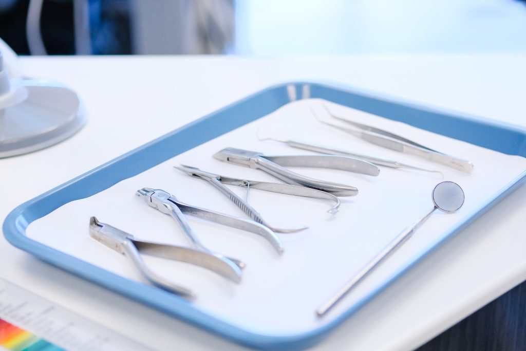 Medical instruments sit on a blue tray