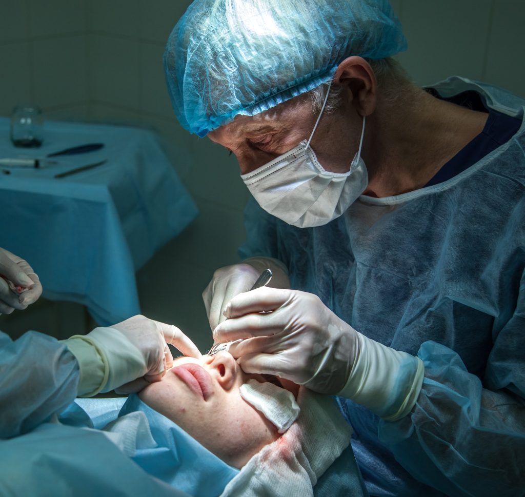 A doctor performs surgery on an eye