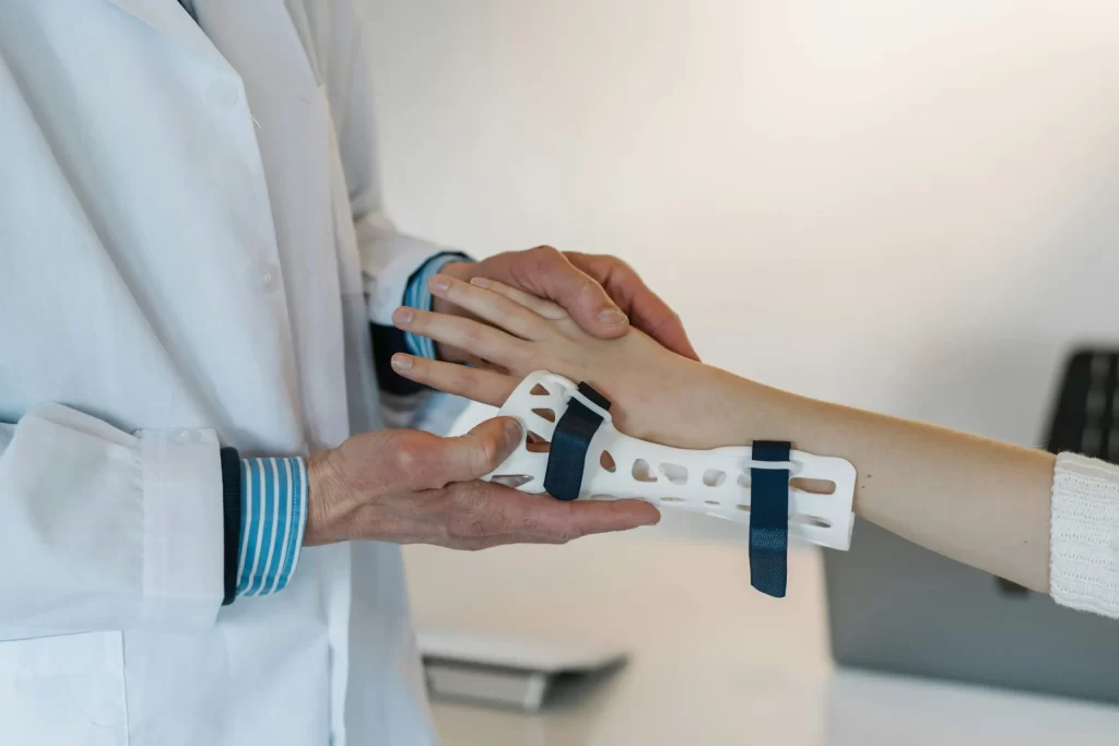 An orthopedic specialist puts a brace on a patient's wrists